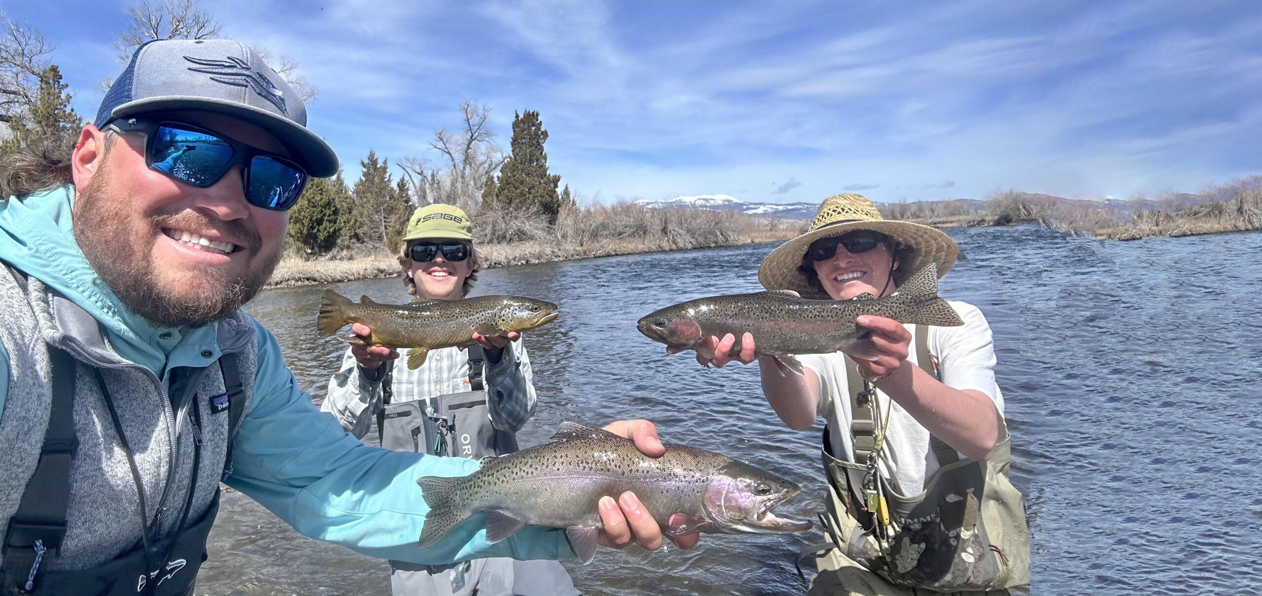 three guides, each holding a fish