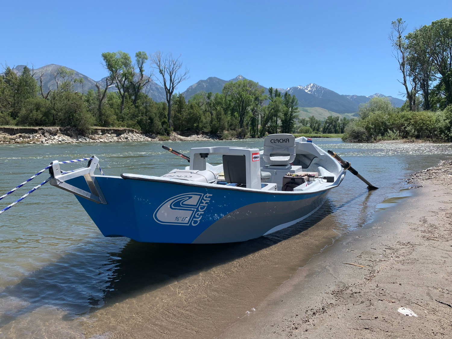 blue drift boat on shore